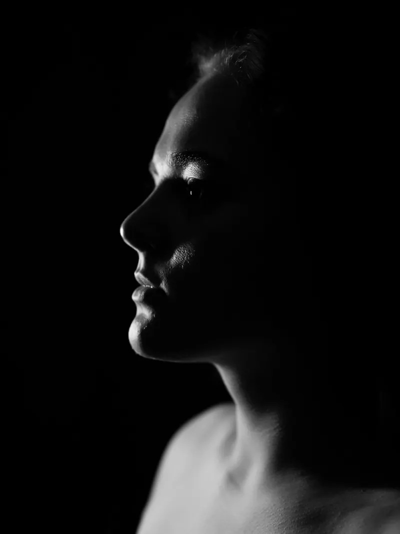 Low-key profile of a person against a black background