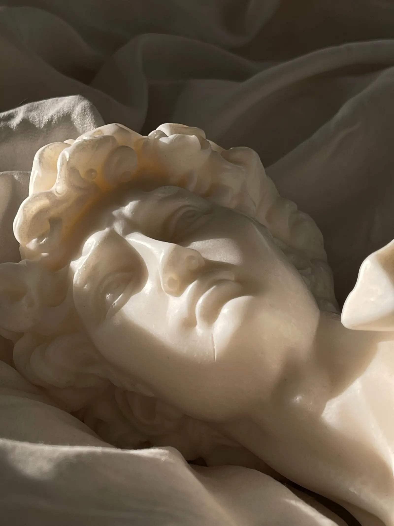 Marble sculpture of a face in dramatic side light